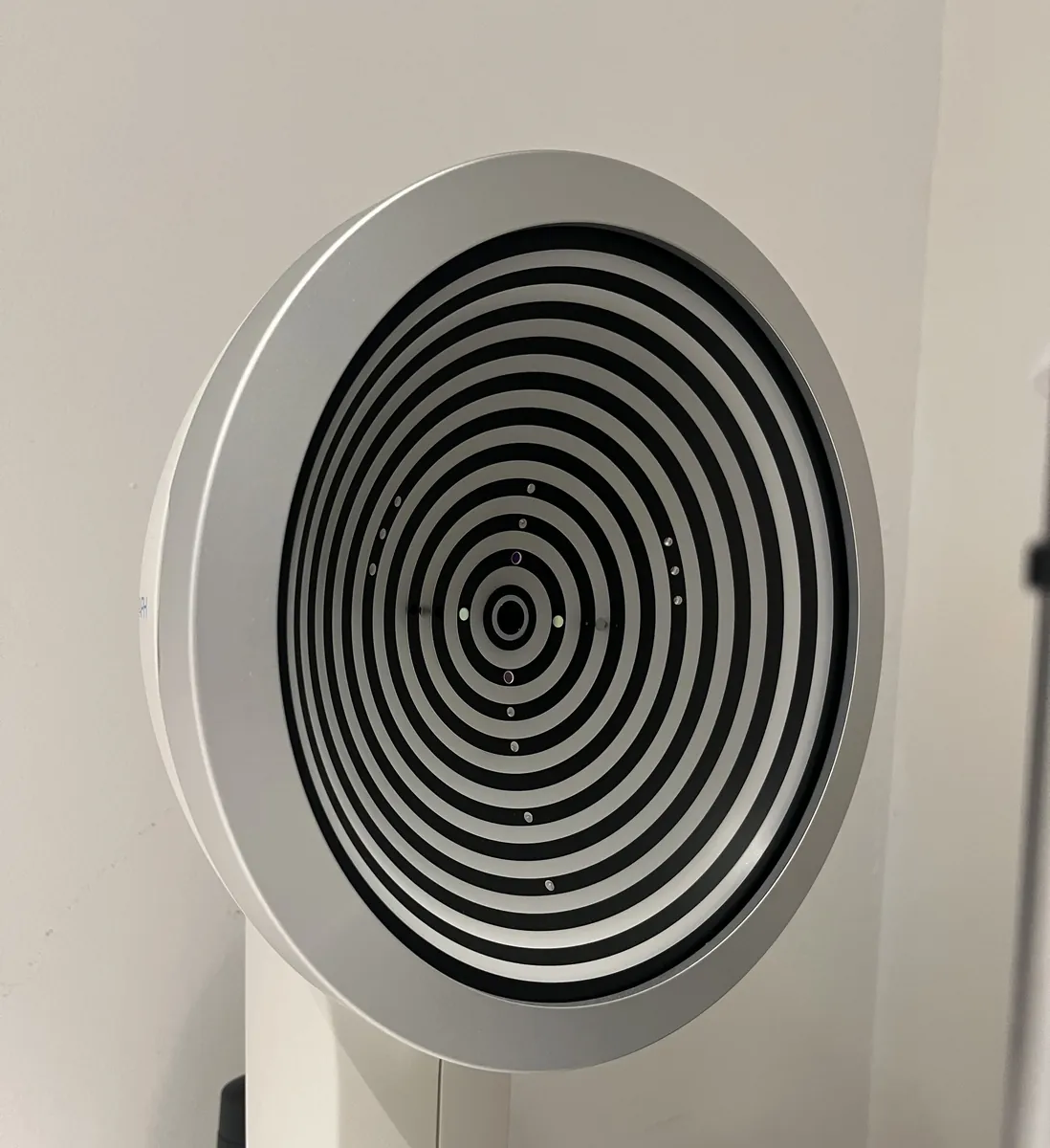 Equipo de medición ocular con un gran disco de anillos concéntricos negros y grises